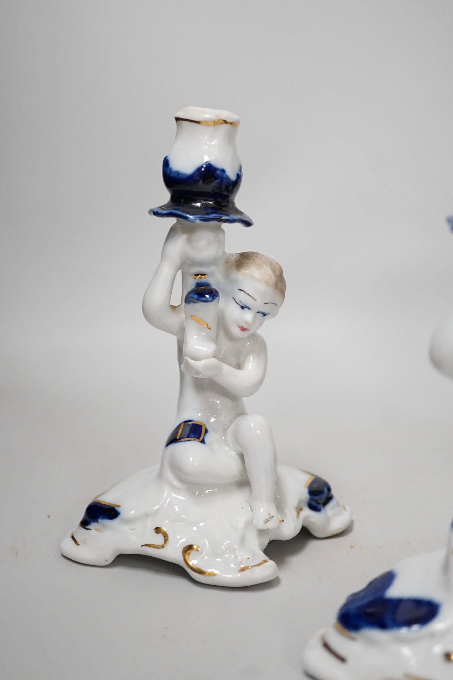 A pair of candlesticks and a figure group flower vase. Tallest 20cm